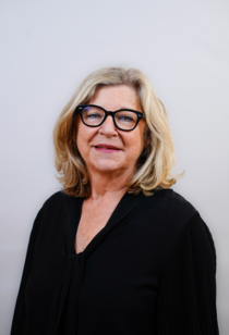 Porträtfoto einer Frau mit halblangen blonden Haaren und Brille.